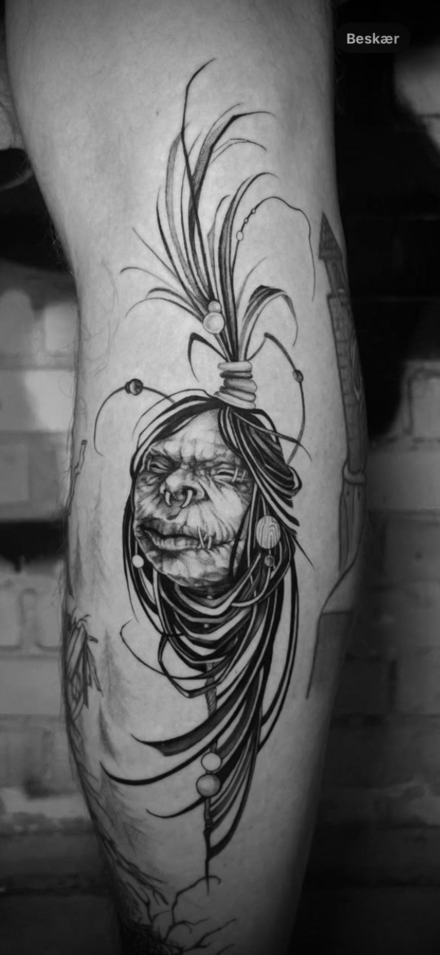 Dark fantasy-tatovering med skrumpet hoved på læggen